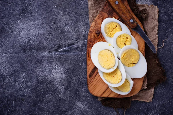 Ovos de galinha fatiados cozidos na tábua de corte — Fotografia de Stock