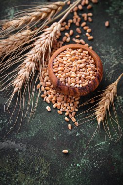 Buğday taneleri ve paslı arka plan üzerinde spikelets.