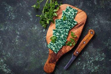 Yeşil otlar peyniri dilimlenmiş.