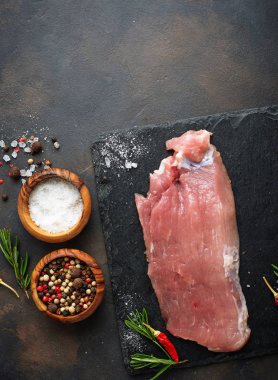 Çiğ et biftek paslı arka plan üzerinde baharatlar ile