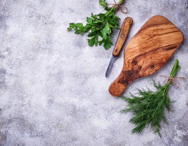 Dereotu, maydanoz ve kesme tahtası