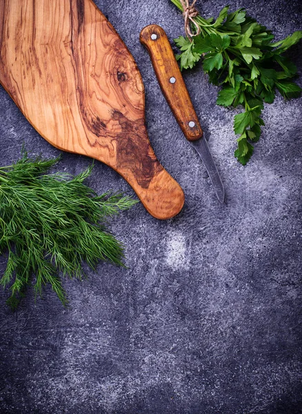 Dereotu, maydanoz ve kesme tahtası