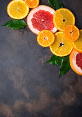 Farklı beton koyu arka plan üzerinde narenciye dilimlenmiş