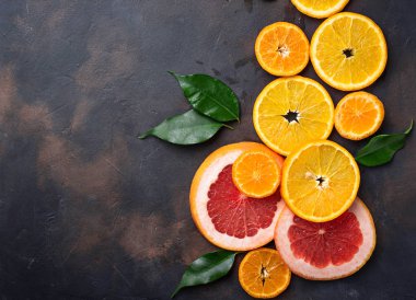 Farklı beton koyu arka plan üzerinde narenciye dilimlenmiş