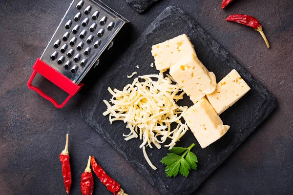 Grated cheese on slate board — Stock Photo, Image
