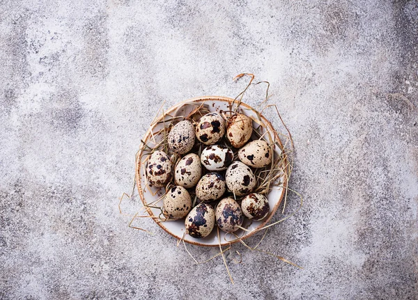 Uova di quaglia e paglia su fondo chiaro — Foto Stock