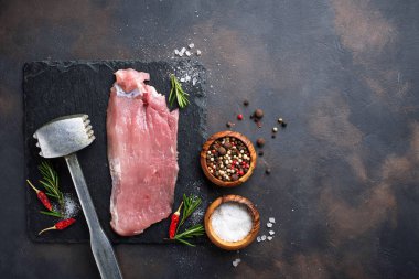 Çiğ et biftek paslı arka plan üzerinde baharatlar ile