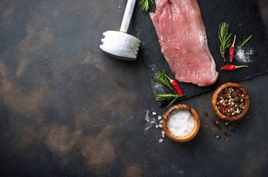 Çiğ et biftek paslı arka plan üzerinde baharatlar ile