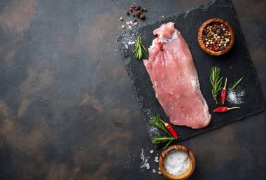 Çiğ et biftek paslı arka plan üzerinde baharatlar ile