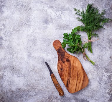 Dereotu, maydanoz ve kesme tahtası