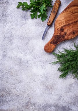 Dereotu, maydanoz ve kesme tahtası