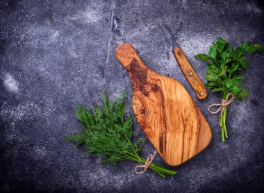 Dereotu, maydanoz ve kesme tahtası