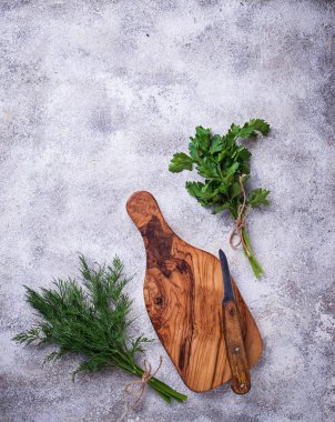 Dereotu, maydanoz ve kesme tahtası