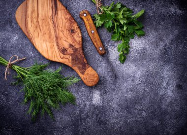 Dereotu, maydanoz ve kesme tahtası
