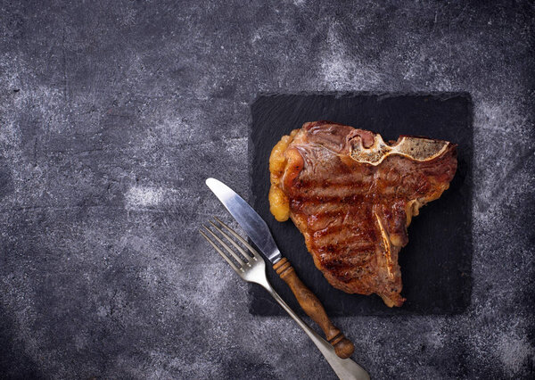 Grilled T-bone steak on dark background