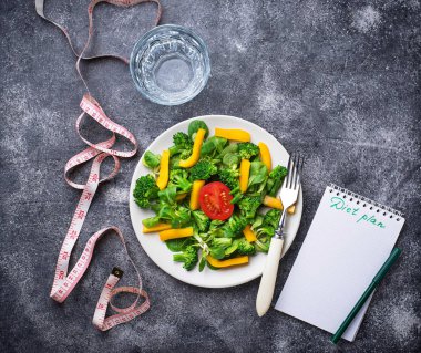 Sağlıklı salata, temiz su ve ölçüm bandı.  