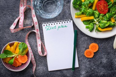 Sağlıklı salata, temiz su ve ölçüm bandı.  