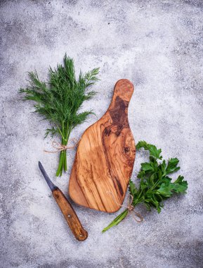 Dereotu, maydanoz ve kesme tahtası