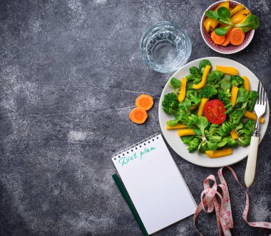 Sağlıklı salata, temiz su ve ölçüm bandı.  