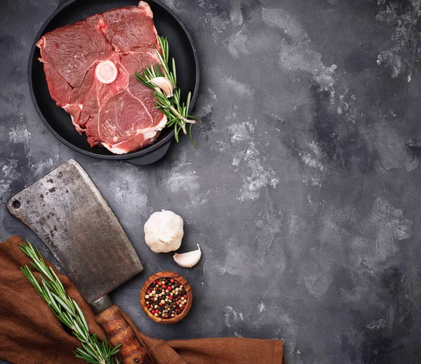 Mięso jagnięce z rozmarynem, przyprawy i tasak. — Zdjęcie stockowe