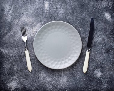 Boş levha ve beton masada Gümüş eşyalar