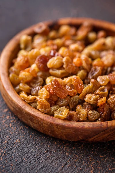 Raisins in wooden bowl on rusty background — Stock Photo, Image