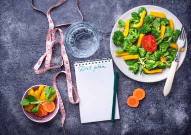 Sağlıklı salata, temiz su ve ölçüm bandı.  