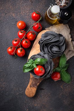 Domates ve fesleğen ile siyah pişmemiş makarna
