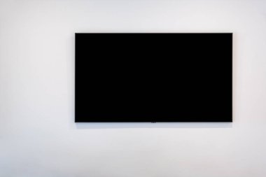 Beyaz duvarda, kopyalama alanı olan siyah düz ekran televizyon