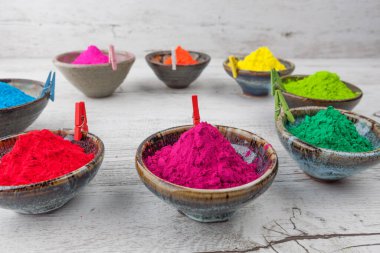 Mandallarla çevrelenmiş bardaklarda canlı renkli Holi tozu. Üst görünüm