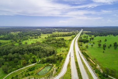 Parlak güneşli bir günde kırsaldan geçen otobanın havadan görünüşü