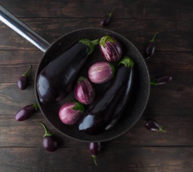 Patlıcanlar ahşap masaya yerleştirilmiş tavaya yerleştirilmiş. Üst görünüm.