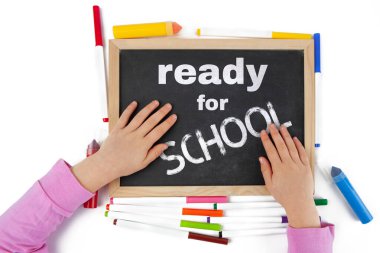 Okul konseptine hazırlanıyorum. Tahtada yazılı çocuk elleriyle tasvir ediliyor. Üst görünüm.