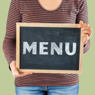 Kadının elleri, vücudun önünde üzerinde Menü yazan küçük siyah karatahtayı tutuyor.