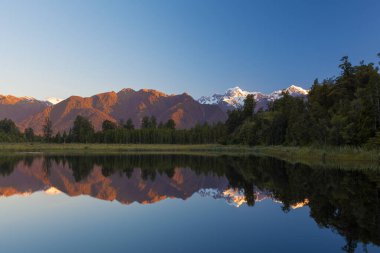 Twin Peaks reflect in the beautiful Lake Matheson at sunset, Southern Alps, South Island, New Zealand clipart