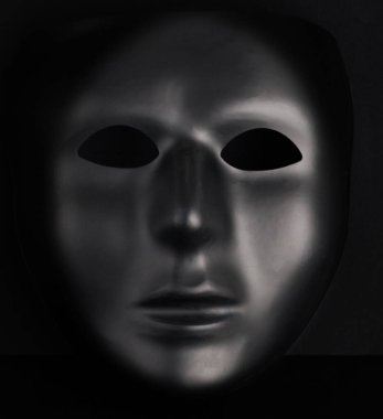Zifiri karanlık arka plandan çıkan isimsiz siyah maske. Anonimlik kavramı
