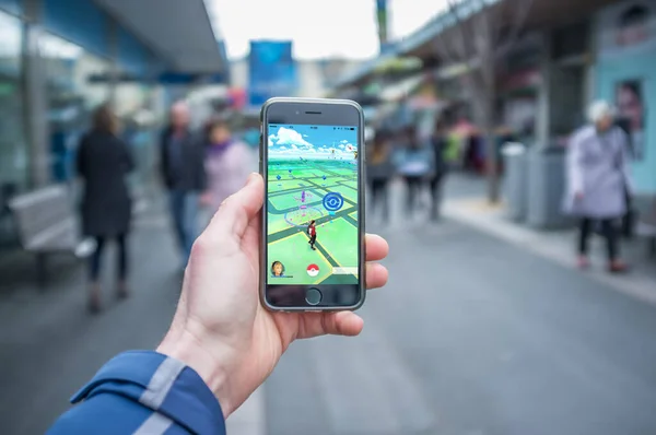 Melbourne, Avustralya - 12 Ağustos 2016: Yoğun bir sokakta Pokemon Go oyunu ile iPhone 6 'yı tutan erkek