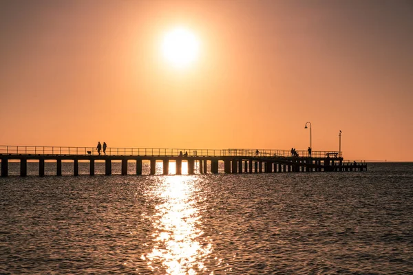 Sylwetki Ludzi Cieszących Się Zachodem Słońca Nad Oceanem Drewnianym Molo — Zdjęcie stockowe