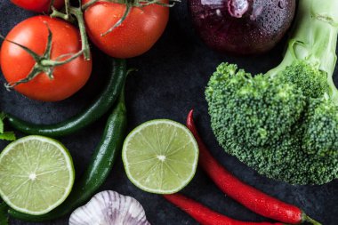 Domates, acı biber, sarımsak, soğan, limon ve arkaplanda brokoli. Üst görünüm.