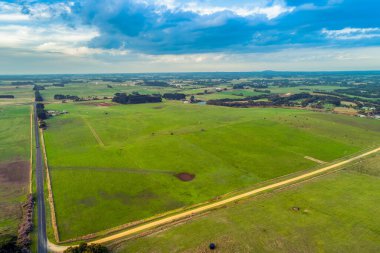 Avustralya kırsalındaki manzaralı otlakların içinden geçen yolların havadan görünüşü
