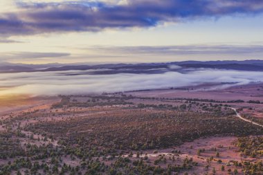 Dağlık arazide sabahın erken saatlerinde bulutlar yere seriliyordu.