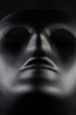 Zifiri karanlık arka plandan çıkan isimsiz siyah maske. Kahraman vuruşu. Anonimlik kavramı