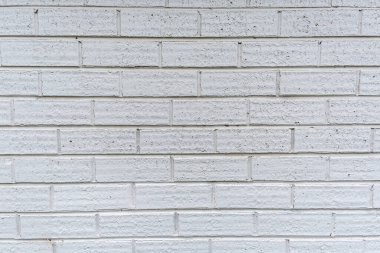 Beyaz arkaplan dokusuyla boyanmış ince modern tuğla duvar.