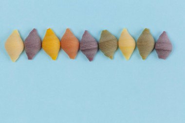 Mavi arka planda renkli sebze kabukları ve kopyalama alanı