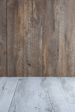 Kahverengi ahşap arka planlı, beyaz bir ahşap masa. Kopyalama alanı olan dikey resim