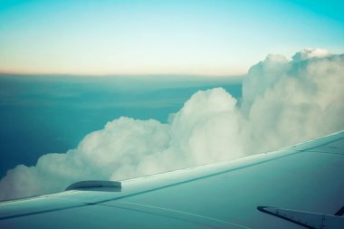 Uçak kanadı ve gökyüzünde yükselen güzel bulutlar