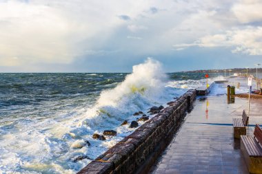 İskeleye ve dalgakırana büyük dalgalar geliyor. Mornington Yarımadası, Victoria, Avustralya