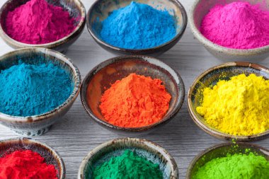 Dolu renkli Holi boyası bardakların içinde. Sığ alan derinliği.