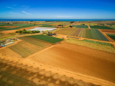 Açık yaz gününde okyanus kıyısı yakınlarındaki tarlaların ve ekinlerin havadan görünüşü. Werribee Güney, Victoria, Avustralya