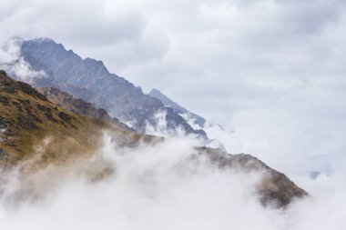 Olağanüstü Kayak Alanında, Queenstown, Yeni Zelanda 'da bulutların üstünde engebeli tepeler.